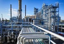 Guards Shut Valve and Kill Three Libyan Oilfields Industrial refinery with pipelines and distillation towers under blue sky