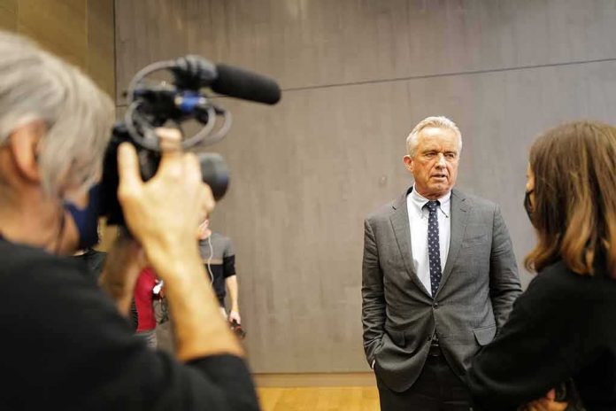 shutterstock_2314962243-1 Man in a gray suit speaks to a reporter during an interview