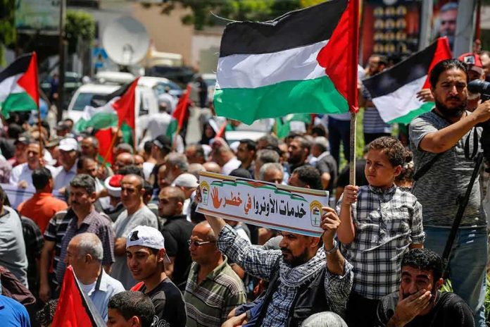 Crowd of protesters holding Palestinian flags in a street demonstration