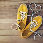 Washington Post Tries to ‘Sneak’ in Some Race Rage Over Shoe Ad Yellow canvas sneakers with laces forming a heart on wooden floor