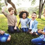 They Were Laughing While 9/11 Victims Were Named group of children sitting on grass laughing in a park