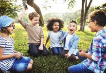 They Were Laughing While 9/11 Victims Were Named group of children sitting on grass laughing in a park