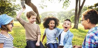 They Were Laughing While 9/11 Victims Were Named group of children sitting on grass laughing in a park