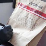 Epstein Accuser Says FBI Waited 15 Years to Contact Her Gloved hands labeling a sealed evidence bag