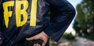 FBI agent in jacket drawing a handgun