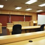 Judge Frees Alleged MS-13 Killer Interior view of an empty courtroom with wooden furniture and American flags