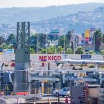 The Mexican Cartels Have an ‘Extermination Ranch’ Border crossing booths at Mexico entry point with cityscape in background