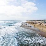 Crowded sandy beach with people by the shoreline