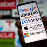 Big Tech AI Gets Midterm Answers From ‘LEFT-LEANING’ Group Hand holding phone displaying tech company logos