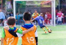 Two boys watching a soccer game together.