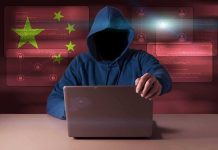 Mansion Realtor Accused of SPYING for China Hooded figure using a laptop with red cybersecurity graphics