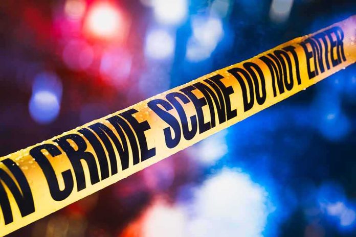 shutterstock_1019775253-1 yellow crime scene tape with blurred police lights