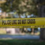 yellow police tape cordoning off an outdoor area