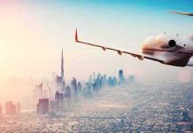 Private jet flying over a modern city skyline at sunrise