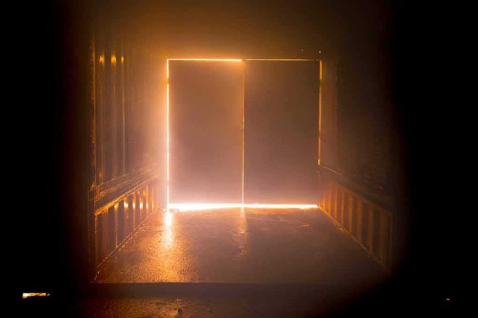 shutterstock_1166358955 Light streaming through a slightly open industrial door