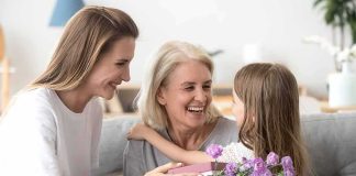 Grandparents Told to Ask PERMISSION to Hug Grandkids Brit Marling smiling with two others as a child gives flowers and a gift