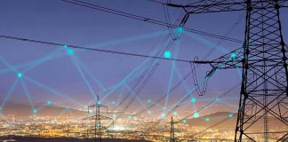 Power transmission towers over a city at dusk with connected network lines