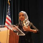 Ilhan Omar Cries ‘RETALIATION’ Over Home Search Ilhan Omar speaking at a podium with a microphone