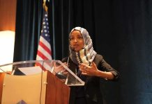 Ilhan Omar Cries ‘RETALIATION’ Over Home Search Ilhan Omar speaking at a podium with a microphone