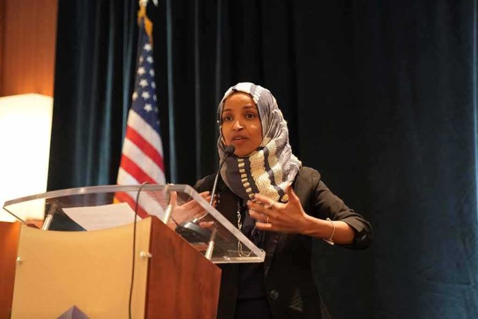shutterstock_1311568823-1 Ilhan Omar speaking at a podium with a microphone