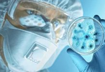 Russia Locks Down Hospitals After Mystery Death Scientist in protective gear examining a petri dish