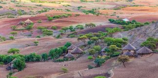 Thatched round huts in a hilly semi-arid landscape