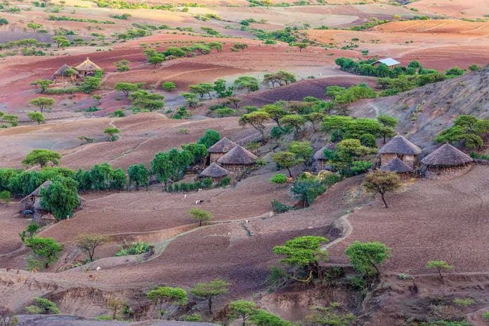 Thatched round huts in a hilly semi-arid landscape