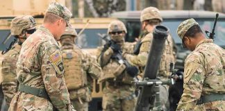 General Says 2027 China WAR Window Holds Soldiers in camouflage gather around a mortar during field training