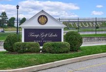 Entrance sign at a golf course with manicured shrubs