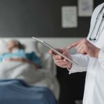 Pope Leo Waits on CANCER Test After Surgery Doctor using tablet beside hospital patient