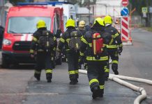 9/11 Families Push Trump for SECRET Records Firefighters walking toward a scene with hoses and a red emergency van