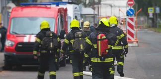 9/11 Families Push Trump for SECRET Records Firefighters walking toward a scene with hoses and a red emergency van