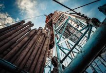 Gas Price Fight ERUPTS on CNN Oil drilling rig structure with stacked pipes viewed from below