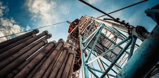 Gas Price Fight ERUPTS on CNN Oil drilling rig structure with stacked pipes viewed from below